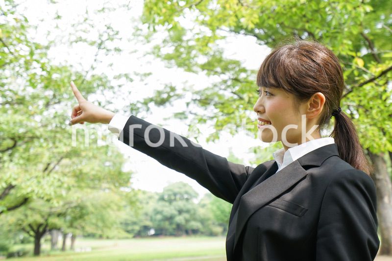 上を指さすビジネスウーマン