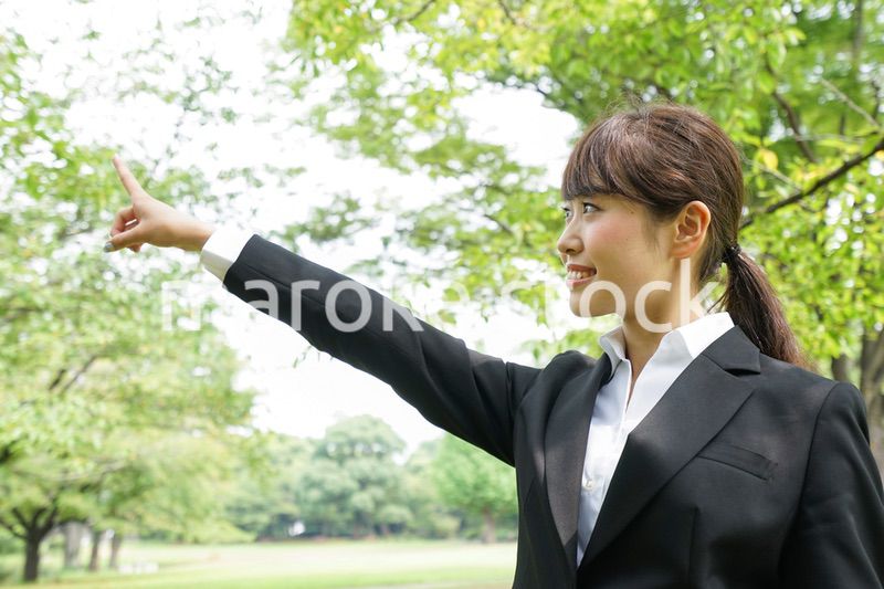 上を指さすビジネスウーマン