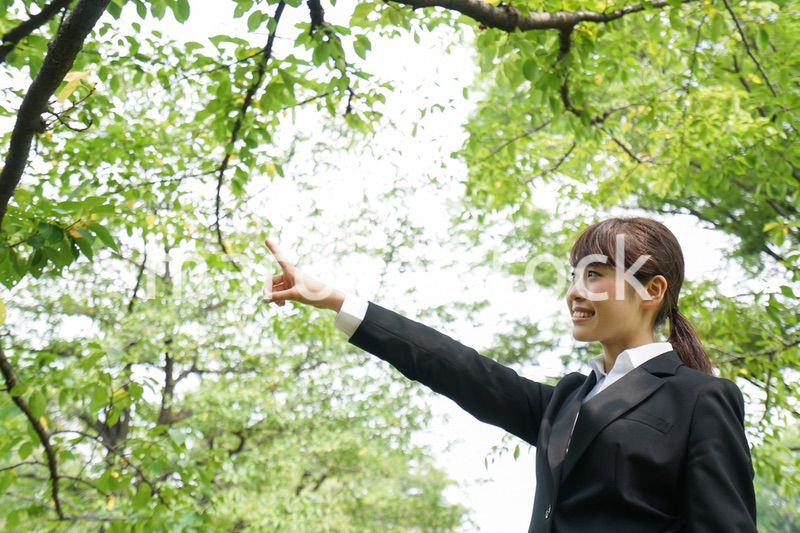 上を指さすビジネスウーマン