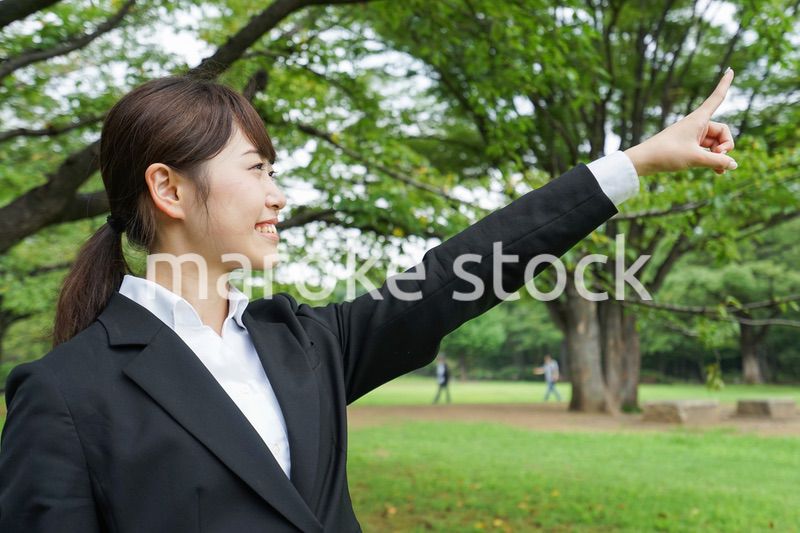 上を指さすビジネスウーマン