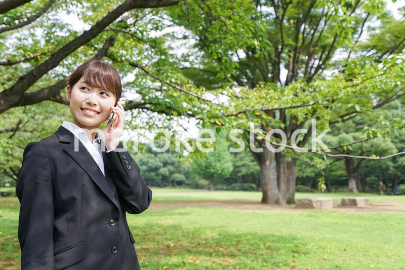 電話をするスーツ姿の若い女性
