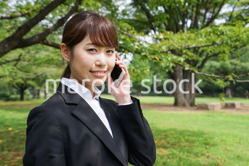 電話をするスーツ姿の若い女性