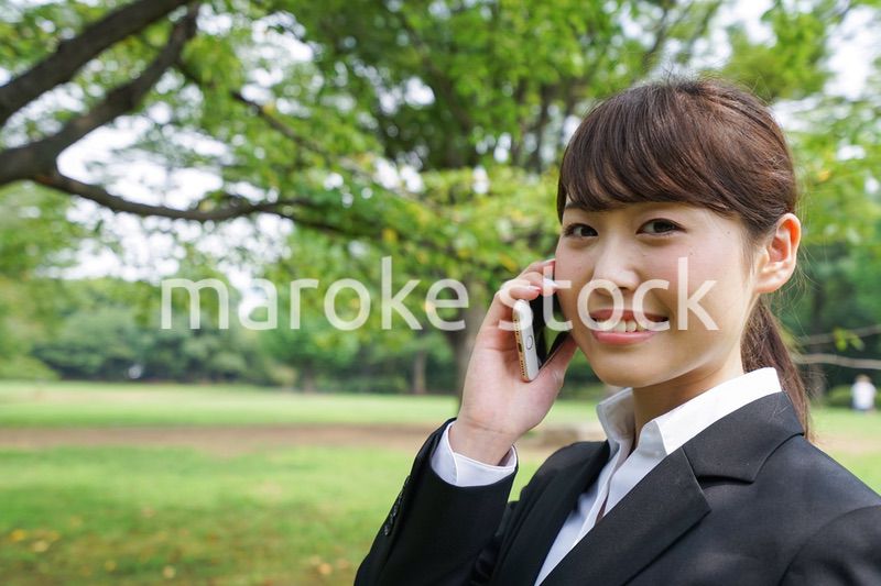 電話をするスーツ姿の若い女性