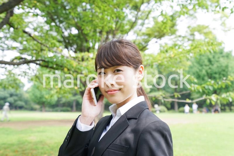 電話をするスーツ姿の若い女性