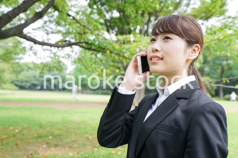 電話をするスーツ姿の若い女性