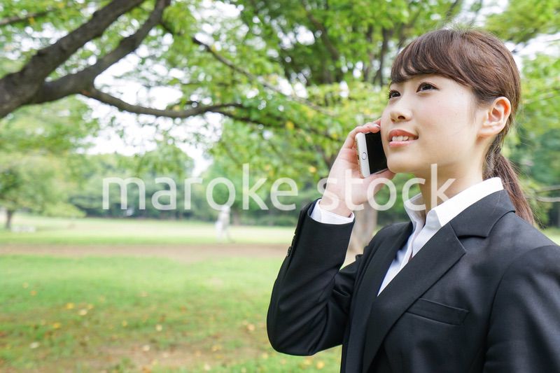 電話をするスーツ姿の若い女性