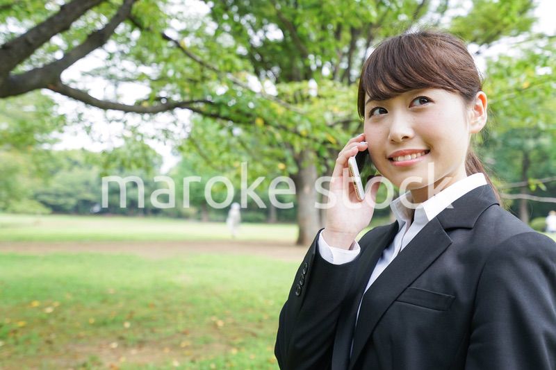 電話をするスーツ姿の若い女性