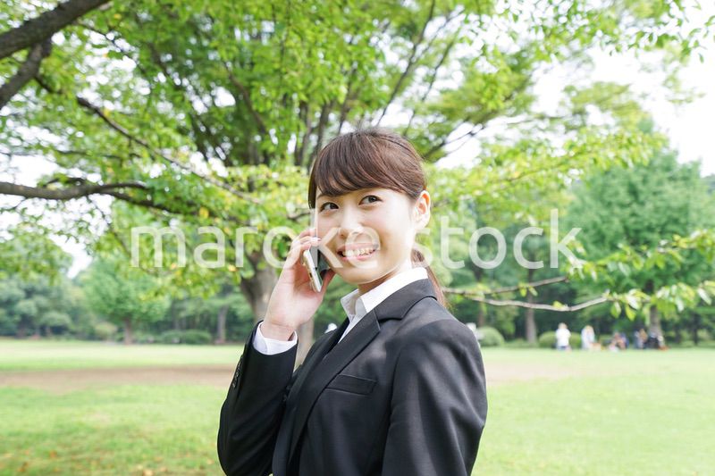 電話をするスーツ姿の若い女性