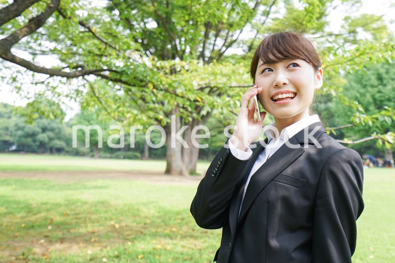 電話をするスーツ姿の若い女性