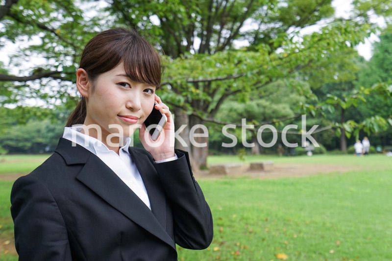 電話をするスーツ姿の若い女性