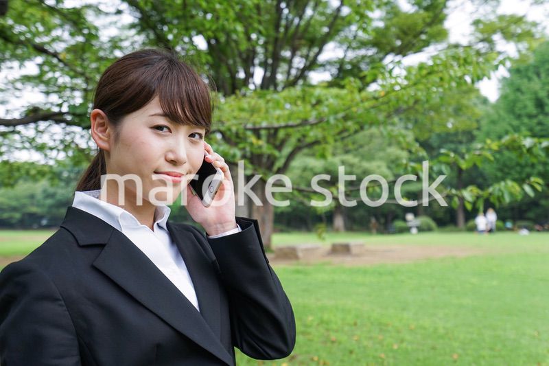 電話をするスーツ姿の若い女性