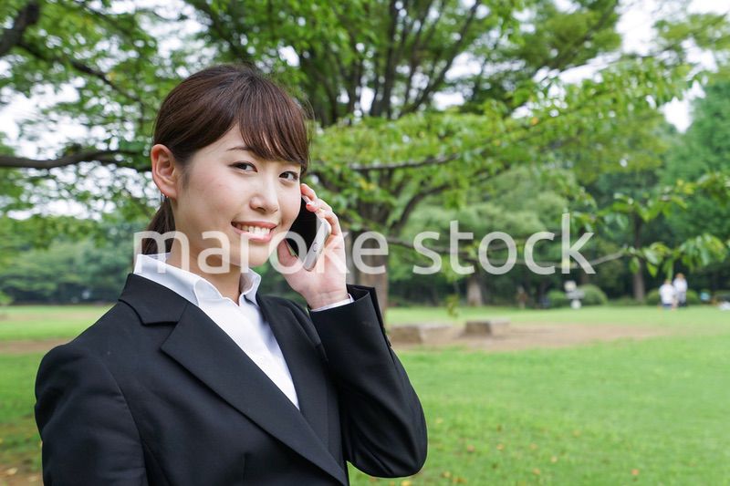 電話をするスーツ姿の若い女性