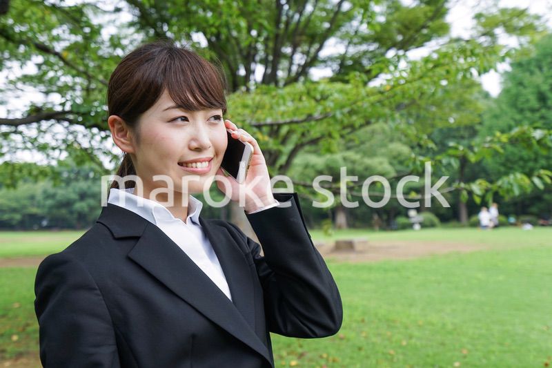 電話をするスーツ姿の若い女性