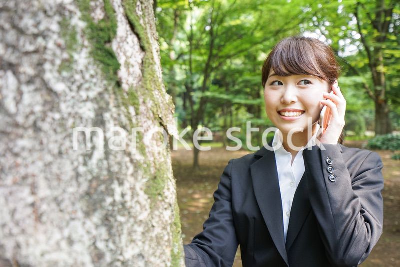 電話をするスーツ姿の若い女性
