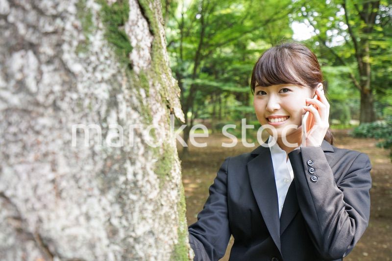 電話をするスーツ姿の若い女性