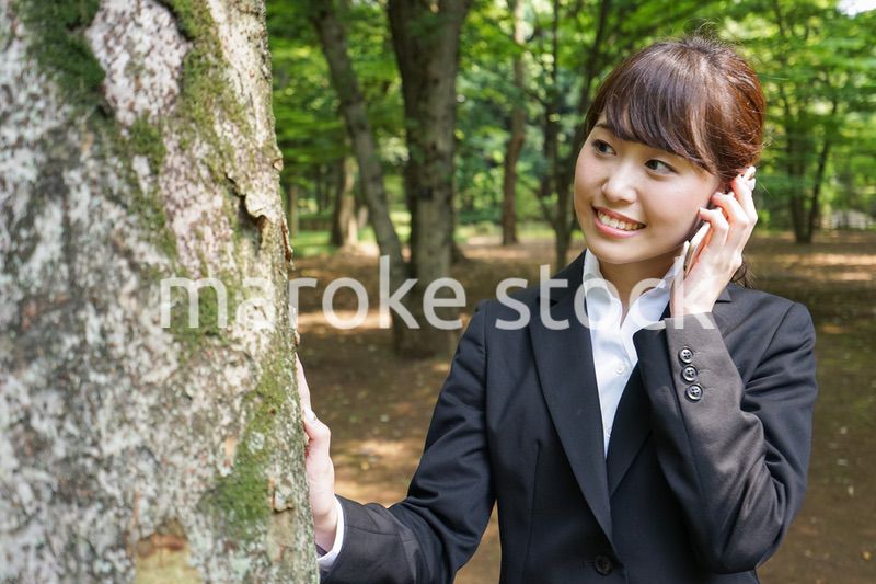 電話をするスーツ姿の若い女性