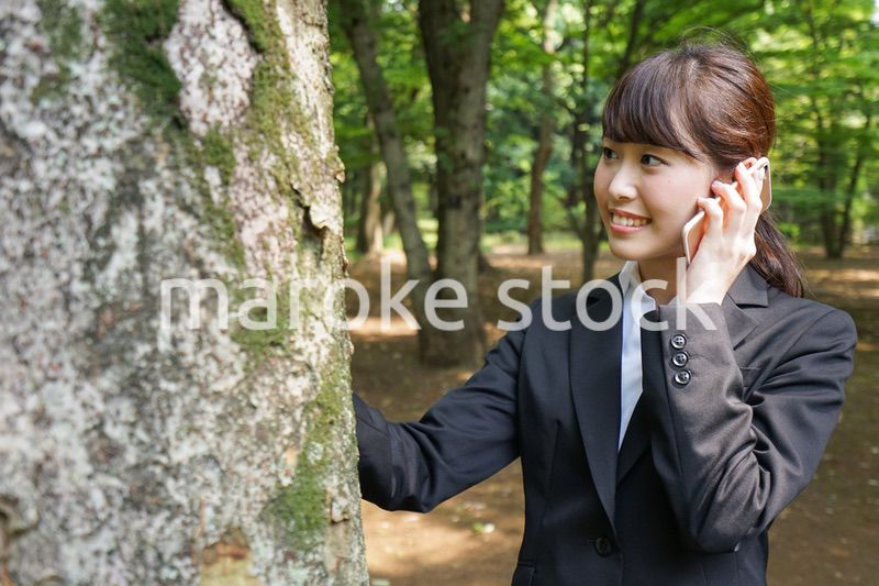 電話をするスーツ姿の若い女性