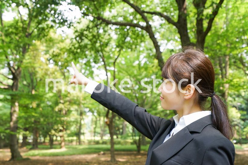 上を指さすビジネスウーマン
