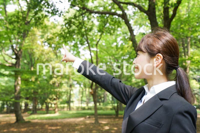 上を指さすビジネスウーマン