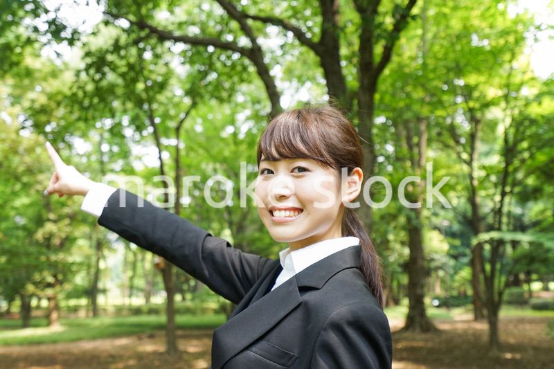 上を指さすビジネスウーマン