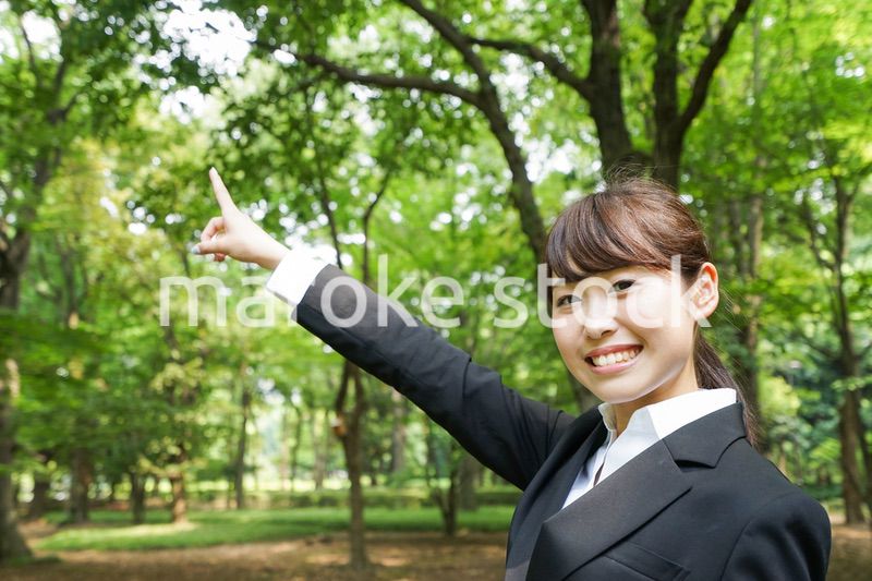 上を指さすビジネスウーマン