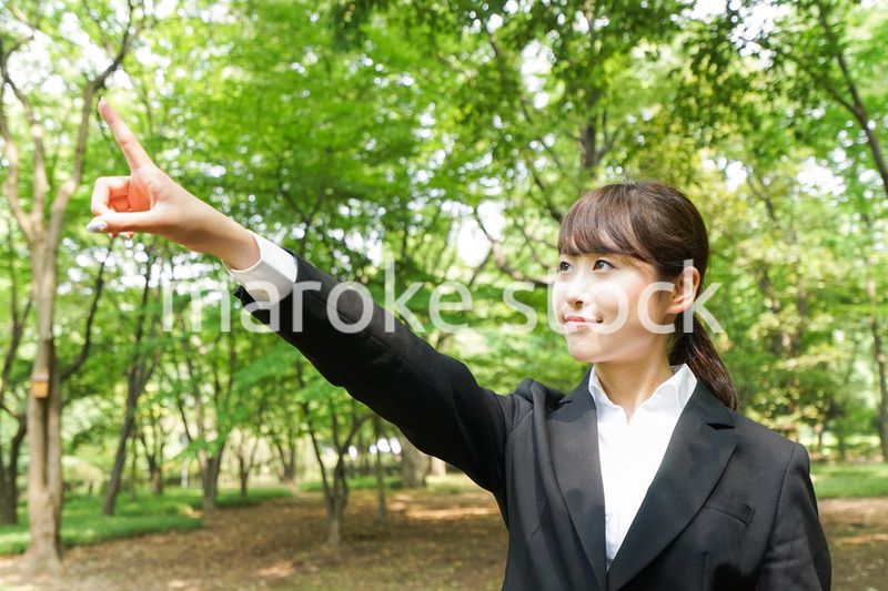 上を指さすビジネスウーマン