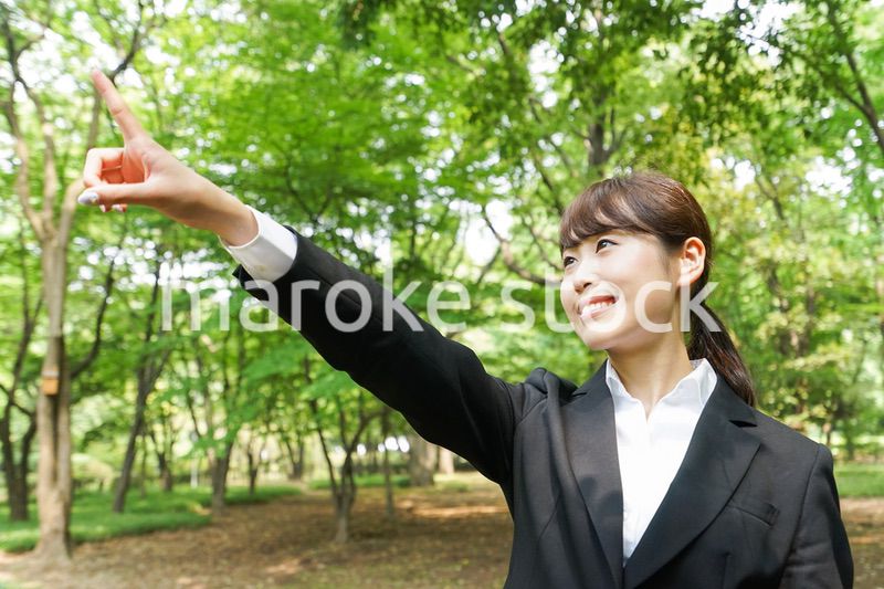 上を指さすビジネスウーマン