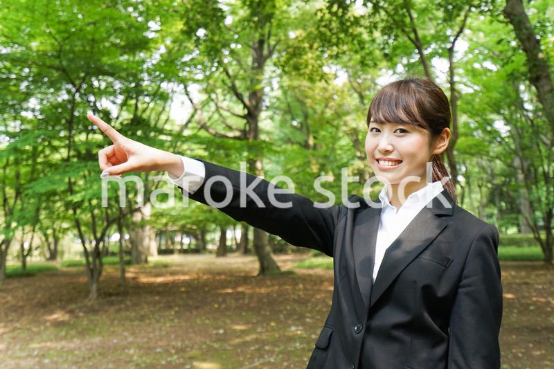 上を指さすビジネスウーマン