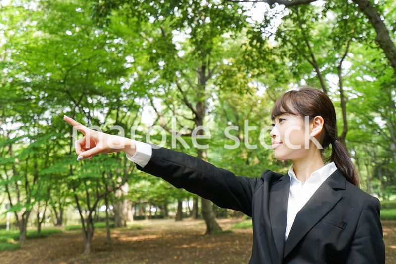 上を指さすビジネスウーマン