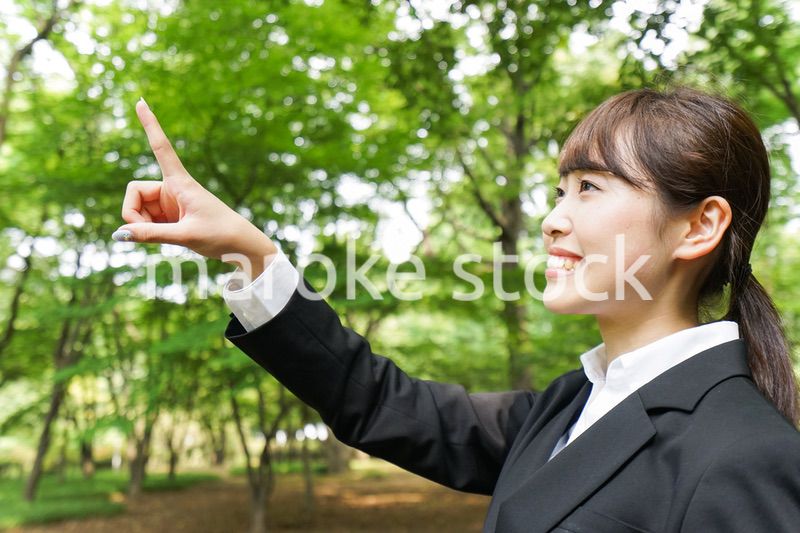 上を指さすビジネスウーマン