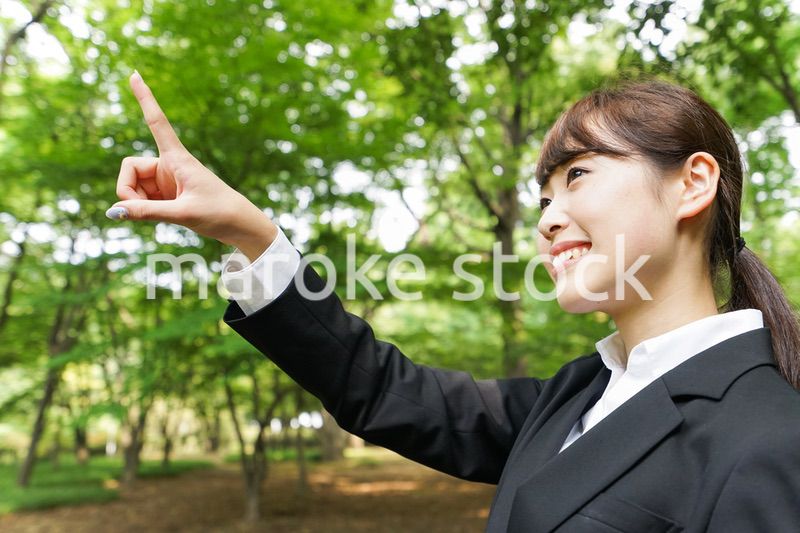 上を指さすビジネスウーマン