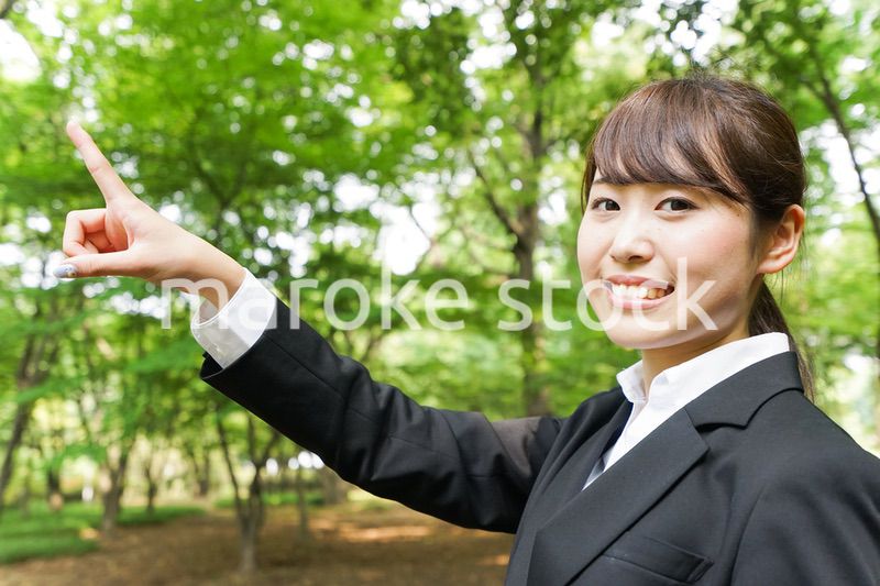 上を指さすビジネスウーマン