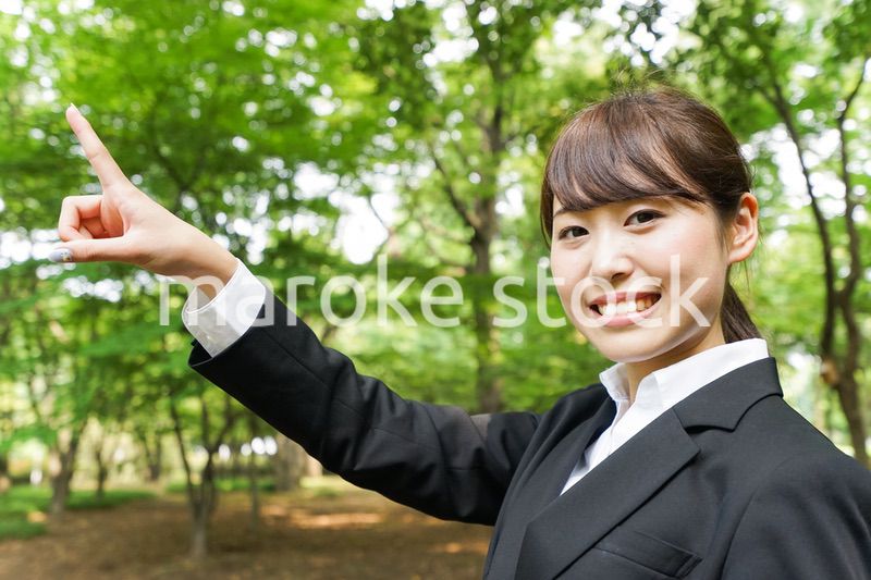 上を指さすビジネスウーマン