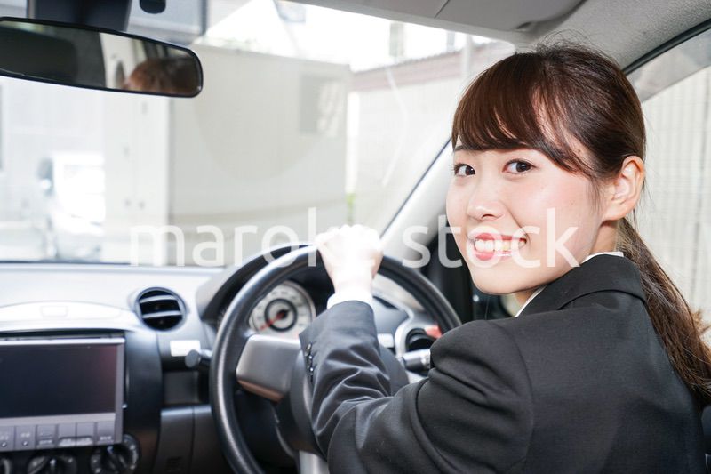 車で外回り営業をする女性
