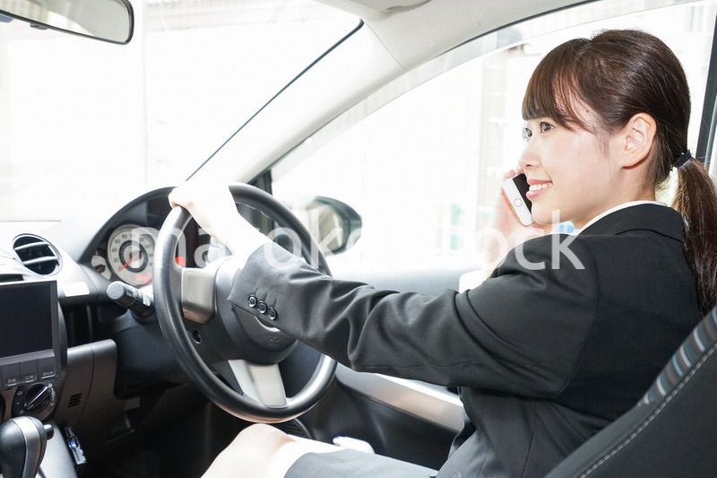 営業車で電話をするキャリアウーマン