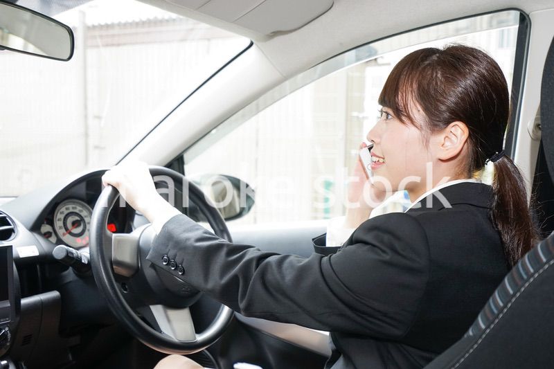 営業車で電話をするキャリアウーマン