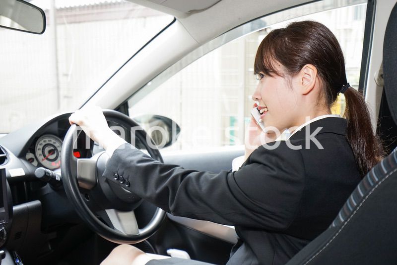 営業車で電話をするキャリアウーマン