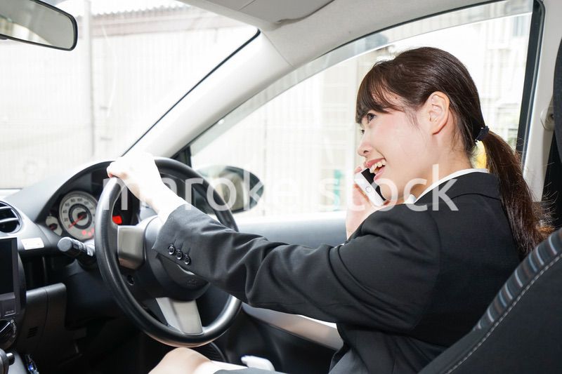 営業車で電話をするキャリアウーマン