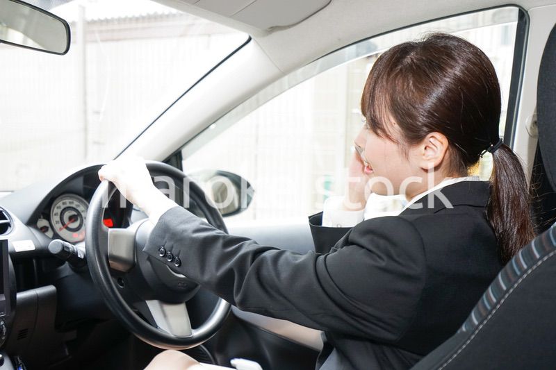 営業車で電話をするキャリアウーマン