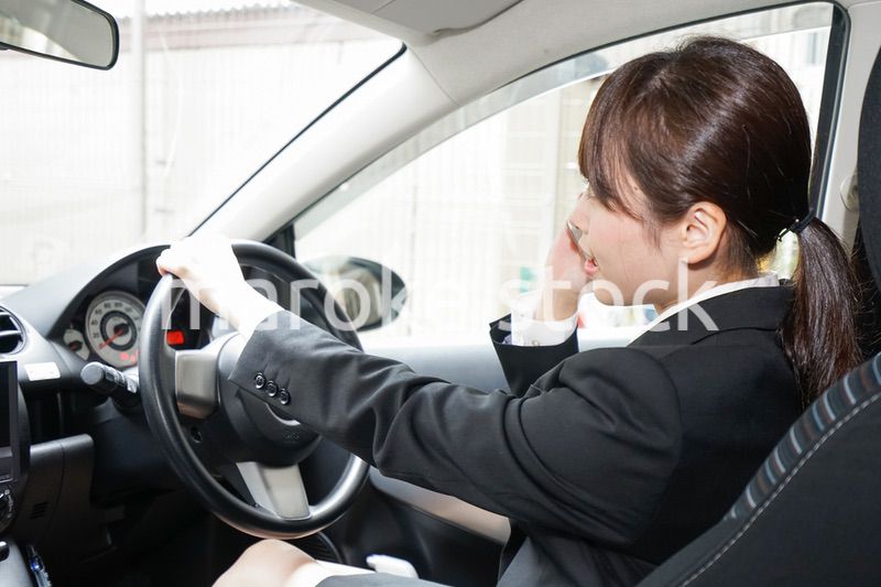 営業車で電話をするキャリアウーマン