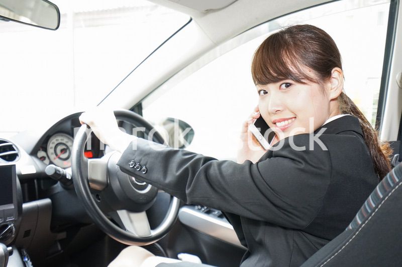 営業車で電話をするキャリアウーマン