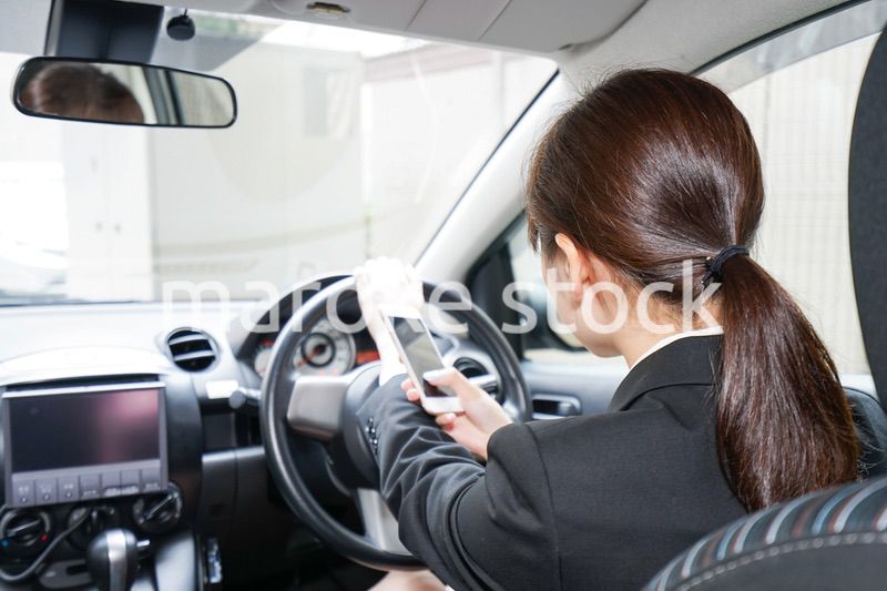 営業車で電話をするキャリアウーマン