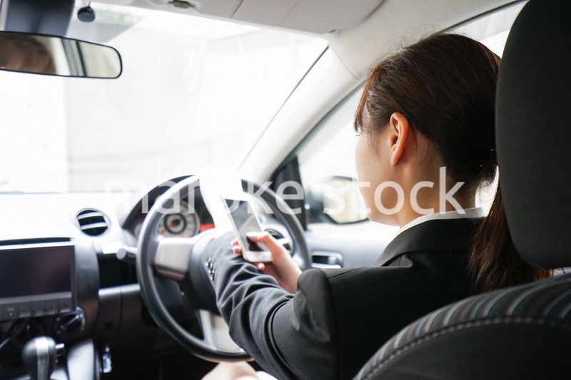営業車で電話をするキャリアウーマン