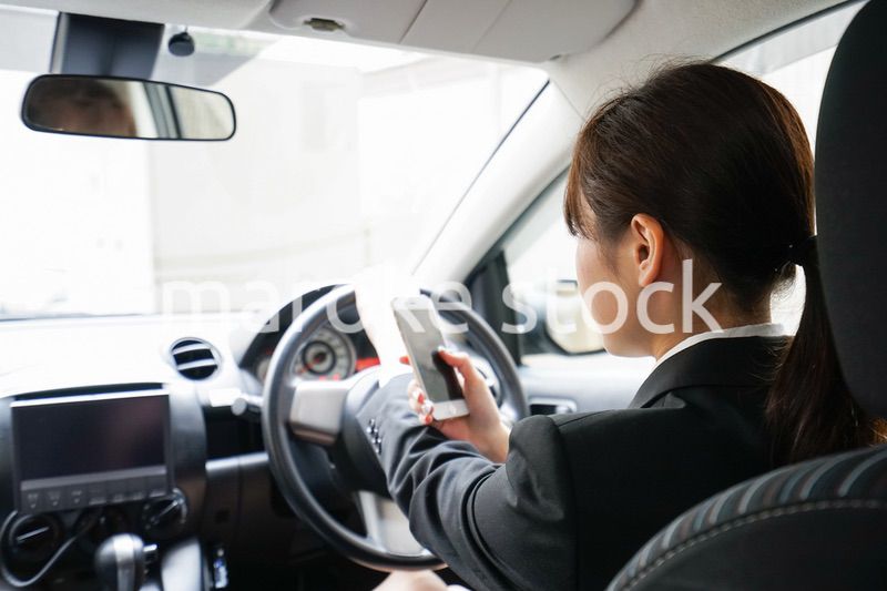 営業車で電話をするキャリアウーマン