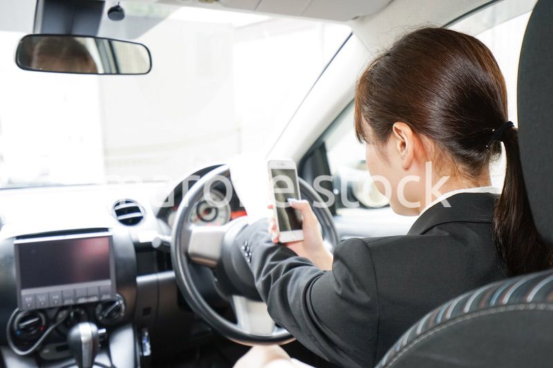 営業車で電話をするキャリアウーマン