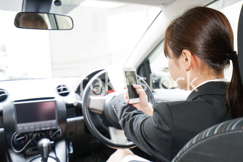 営業車で電話をするキャリアウーマン