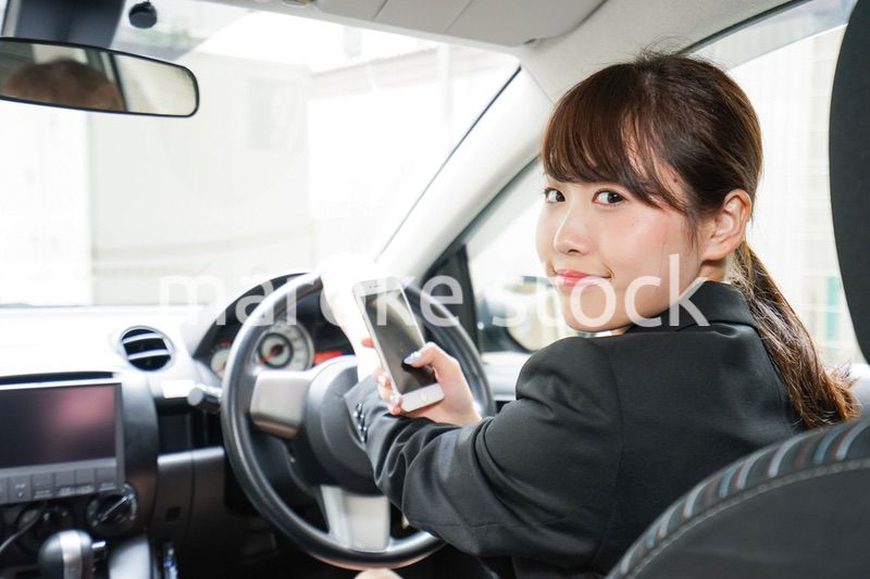 営業車で電話をするキャリアウーマン