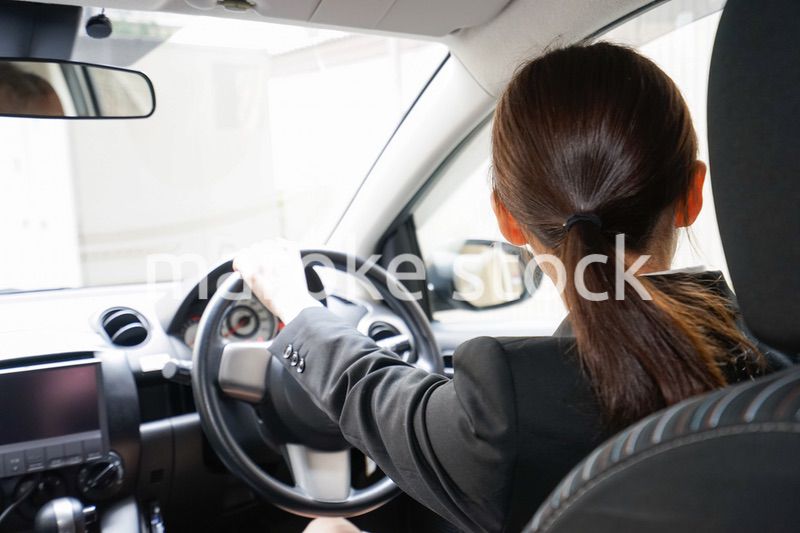 車で外回り営業をする女性