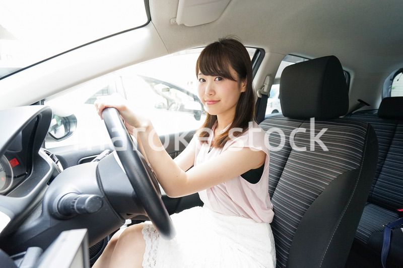 車を運転する若い日本人女性