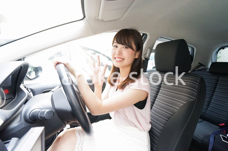 車を運転する若い日本人女性